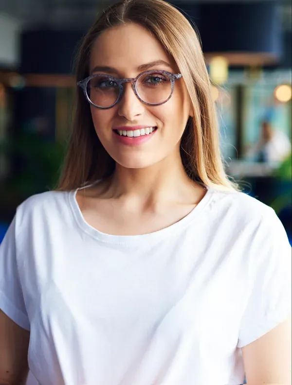An active trader smiling in round glasses and a white T-shirt — Sophie Lecerf